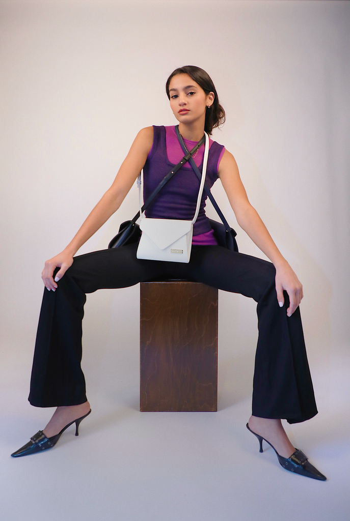 dark haired girl wearing kaila katherine vegan leather brixton clutch shoulderbags in white, black, and navy