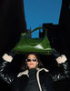 girl wearing coat and sunglasses holding olive colored kaila katherine vegan leather boho bag on her head
